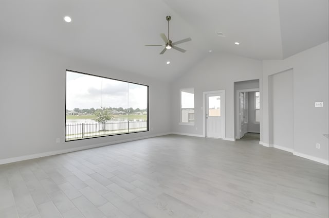 spare room featuring ceiling fan, high vaulted ceiling, light wood-style floors, and baseboards