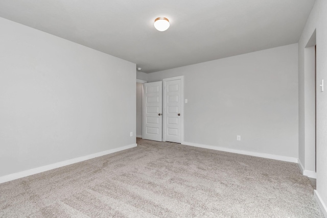 unfurnished bedroom featuring carpet floors and baseboards