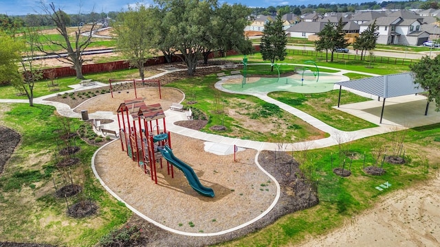 view of property's community featuring a residential view, fence, playground community, and a yard