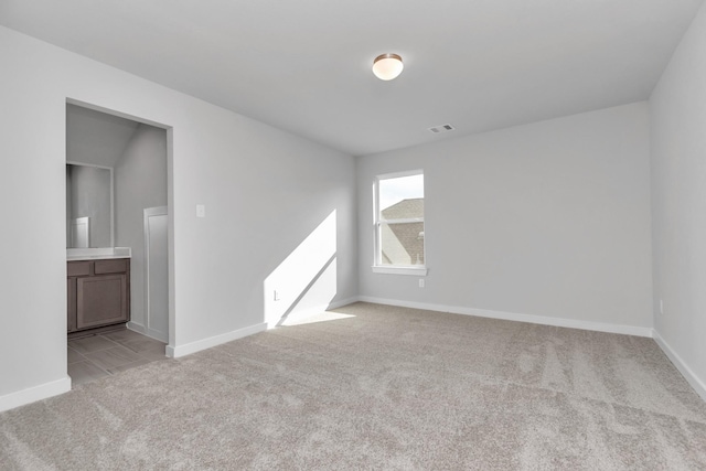 unfurnished room with baseboards, visible vents, and light colored carpet