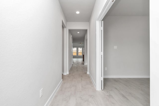 hall with light wood finished floors, recessed lighting, and baseboards