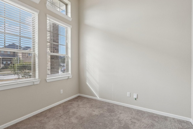 carpeted spare room with baseboards