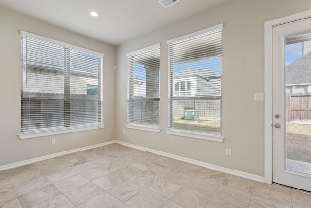 empty room featuring visible vents, recessed lighting, a wealth of natural light, and baseboards