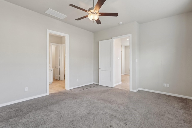 unfurnished bedroom featuring visible vents, ensuite bath, light carpet, and baseboards