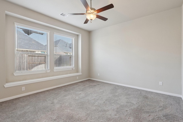 empty room featuring carpet floors, baseboards, visible vents, and a ceiling fan