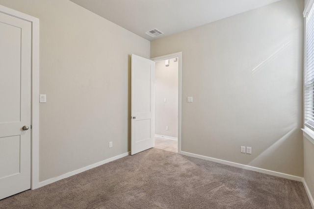 unfurnished bedroom featuring visible vents, light carpet, and baseboards