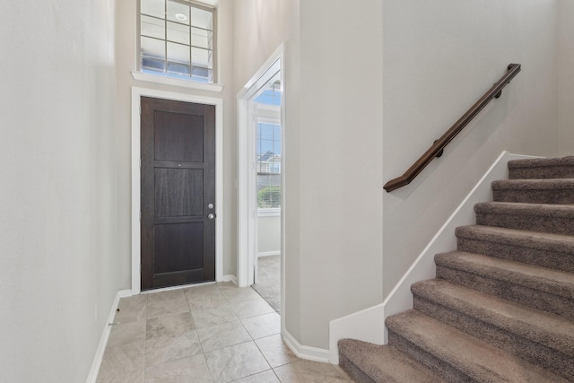 entryway with stairway and baseboards