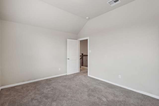 empty room featuring carpet floors, baseboards, visible vents, and vaulted ceiling