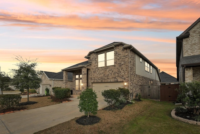 view of front facade with a garage, a lawn, concrete driveway, and brick siding