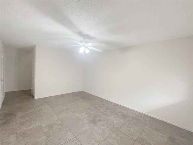 spare room with a textured ceiling, a ceiling fan, and baseboards