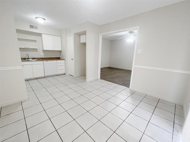 kitchen with a sink, visible vents, white cabinetry, dishwasher, and open shelves