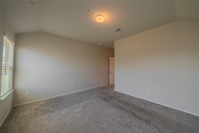 unfurnished room with lofted ceiling, visible vents, and a wealth of natural light