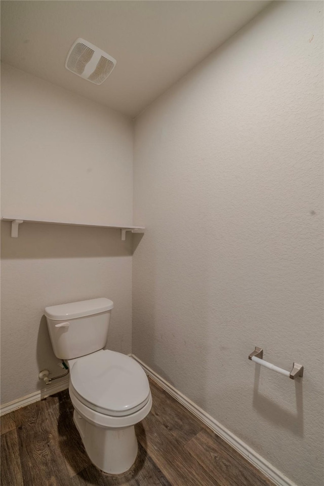 bathroom featuring baseboards, visible vents, toilet, and wood finished floors