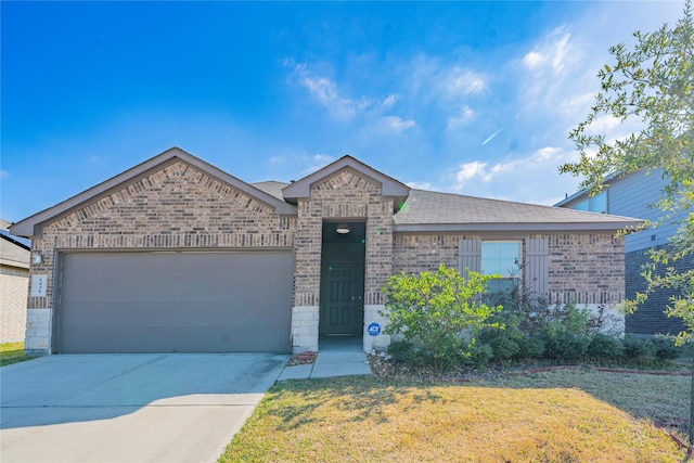 view of front of home with a front yard, concrete driveway, brick siding, and an attached garage