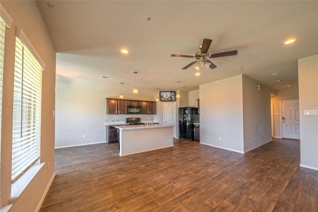 kitchen with dark brown cabinetry, a center island with sink, decorative light fixtures, light countertops, and black appliances