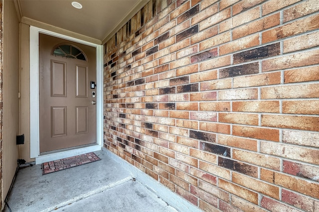 doorway to property featuring brick siding