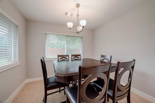 dining room with an inviting chandelier, plenty of natural light, light tile patterned floors, and visible vents