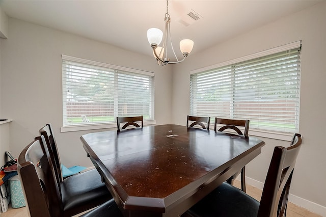 dining room featuring plenty of natural light, a chandelier, and baseboards