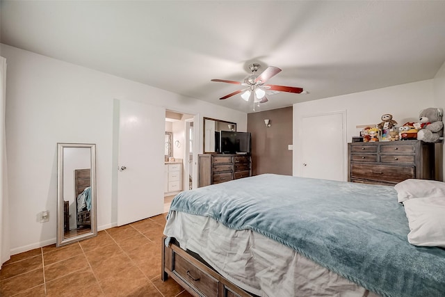 bedroom with ceiling fan, light tile patterned flooring, ensuite bath, and baseboards