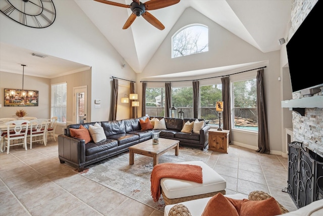 living area with high vaulted ceiling, light tile patterned flooring, ceiling fan with notable chandelier, a fireplace, and visible vents