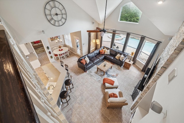 living area with high vaulted ceiling, light tile patterned flooring, and a healthy amount of sunlight