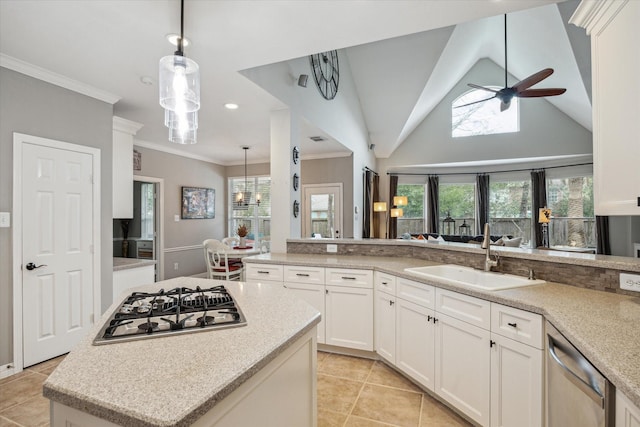 kitchen with a center island, stainless steel appliances, hanging light fixtures, white cabinets, and a sink