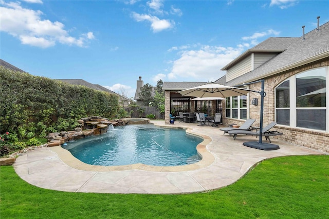 view of swimming pool featuring a patio area, a pool with connected hot tub, a fenced backyard, and a yard