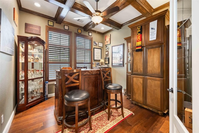 bar with dark wood-type flooring, a dry bar, ceiling fan, and beamed ceiling