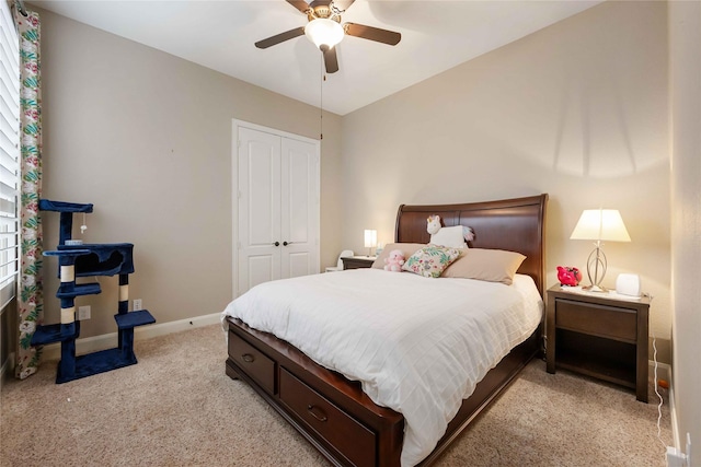 bedroom featuring a closet, light colored carpet, baseboards, and ceiling fan