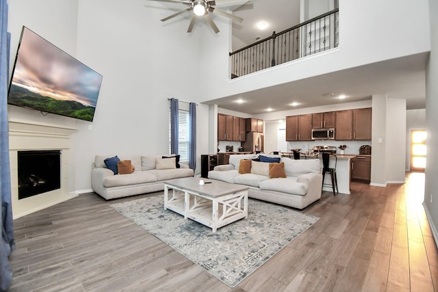 living room featuring light wood finished floors, a fireplace, and baseboards