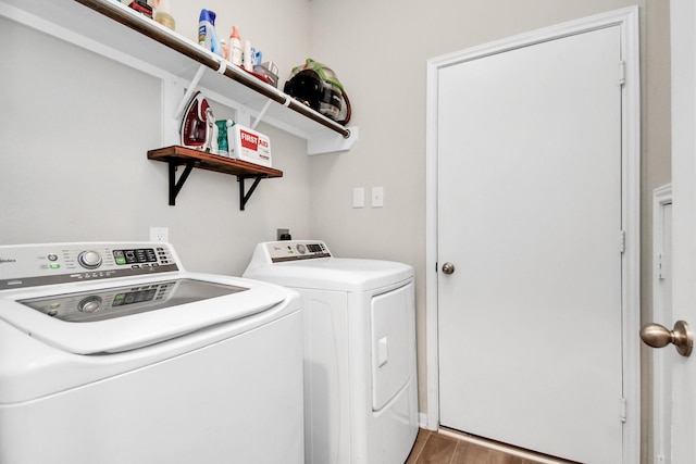 laundry room featuring laundry area, washing machine and clothes dryer, and wood finished floors