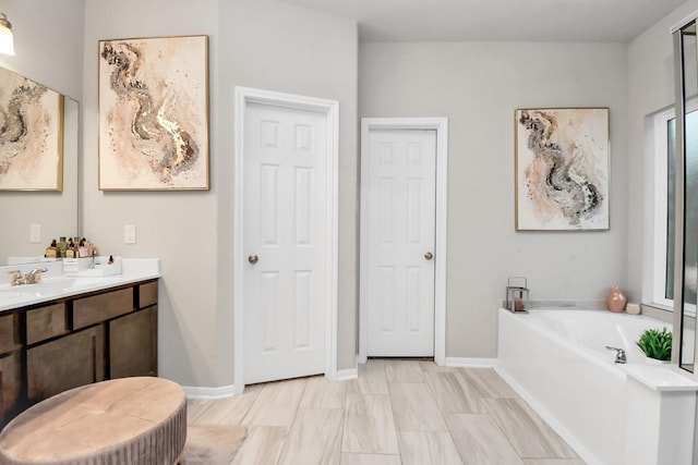 full bathroom featuring a garden tub, baseboards, and vanity