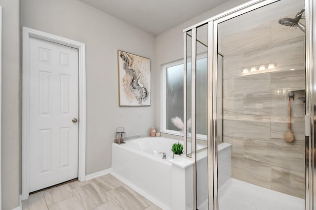 bathroom featuring a shower stall, baseboards, and a bath