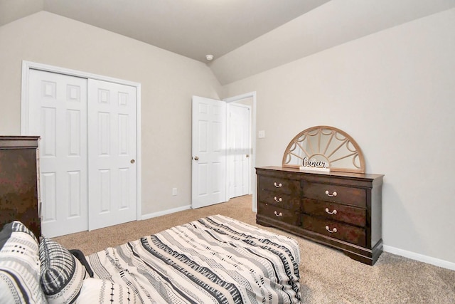 bedroom featuring lofted ceiling, light carpet, baseboards, and a closet