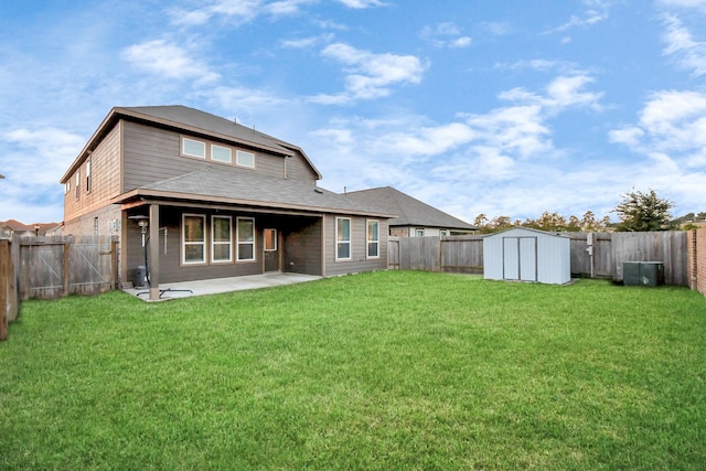 rear view of house with a patio area, a yard, a fenced backyard, and a shed