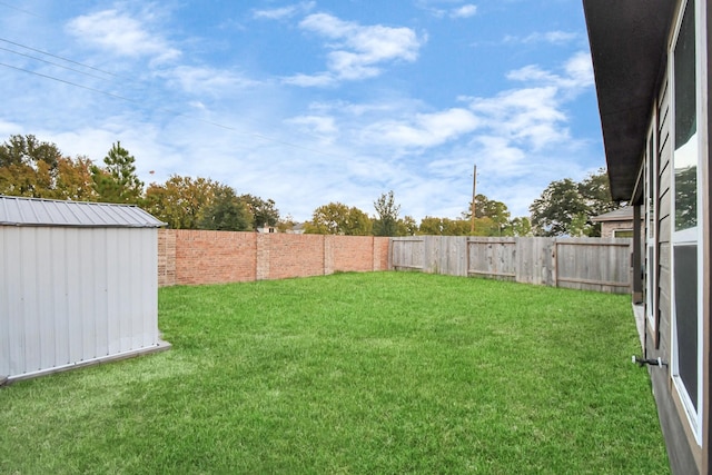 view of yard featuring a storage shed, an outdoor structure, and a fenced backyard