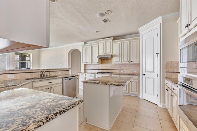 13006 Freemont Peak Ln, Humble, TX 77346 - kitchen featuring appliances with stainless steel finishes, under cabinet range hood, crown molding, backsplash, and a sink