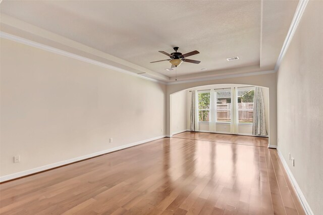 13006 Freemont Peak Ln, Humble, TX 77346 - unfurnished room with a ceiling fan, light wood-style floors, crown molding, baseboards, and arched walkways