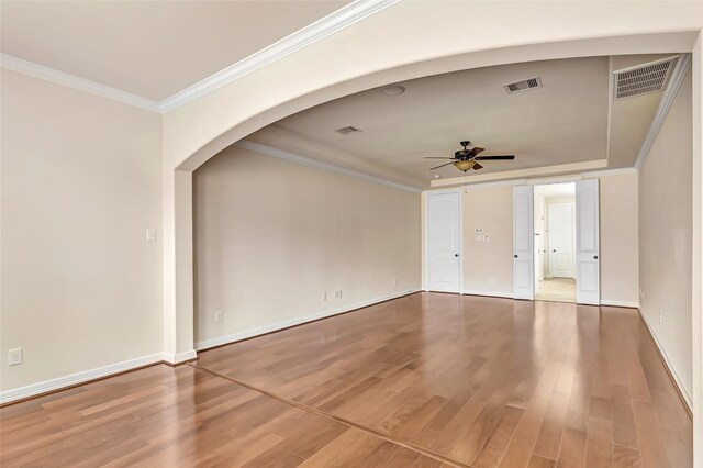 13006 Freemont Peak Ln, Humble, TX 77346 - spare room with ceiling fan, arched walkways, ornamental molding, light wood-type flooring, and baseboards