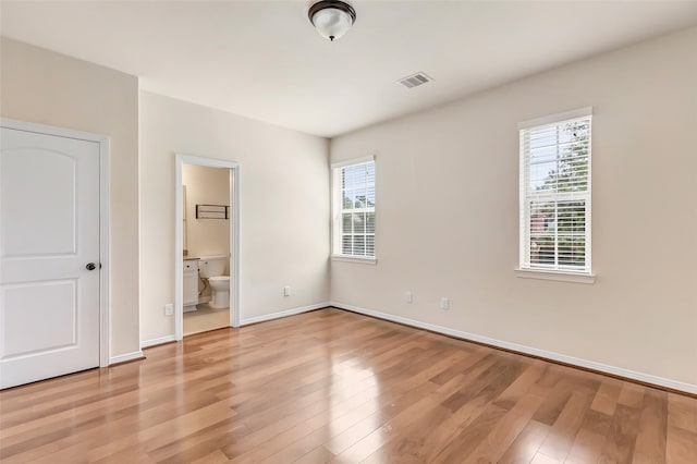 13006 Freemont Peak Ln, Humble, TX 77346 - unfurnished bedroom featuring light wood-style flooring, baseboards, and ensuite bath