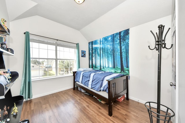 bedroom with lofted ceiling, baseboards, and wood finished floors