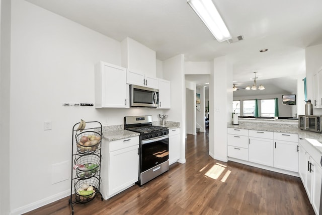 kitchen with light stone counters, visible vents, white cabinetry, appliances with stainless steel finishes, and dark wood finished floors