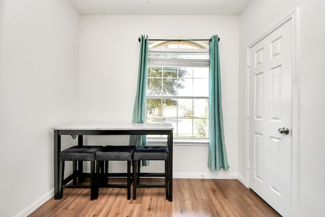 dining space with baseboards and wood finished floors