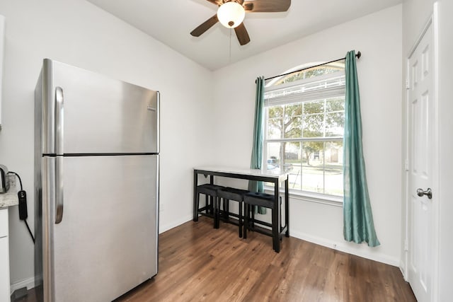 interior space with ceiling fan, baseboards, and wood finished floors