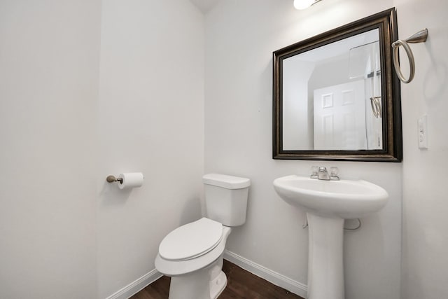 bathroom featuring toilet, baseboards, and wood finished floors