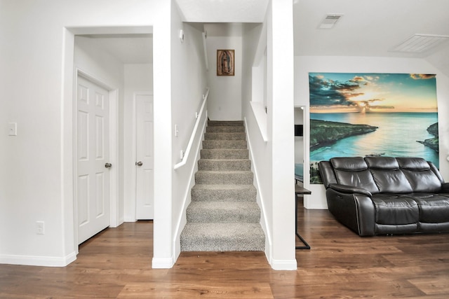 stairs with visible vents, baseboards, and wood finished floors