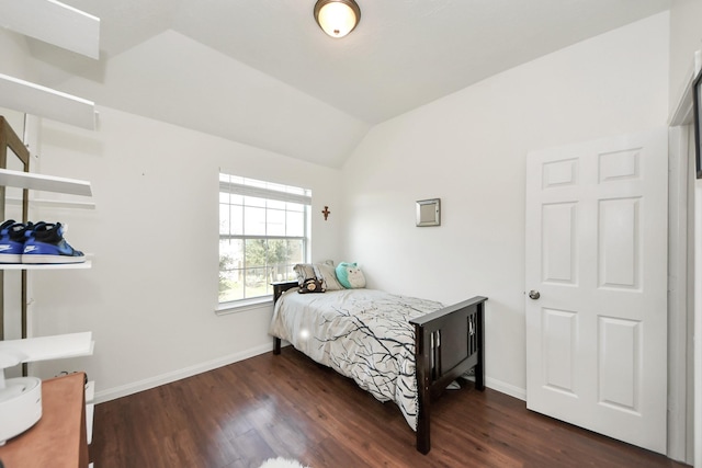 bedroom featuring dark wood finished floors, vaulted ceiling, and baseboards