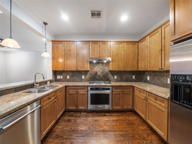 kitchen with light stone counters, pendant lighting, stainless steel appliances, a sink, and under cabinet range hood