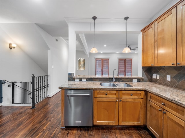 kitchen with a sink, a peninsula, stainless steel dishwasher, and decorative light fixtures