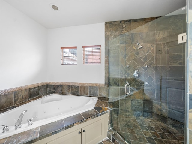 bathroom with a jetted tub and a stall shower